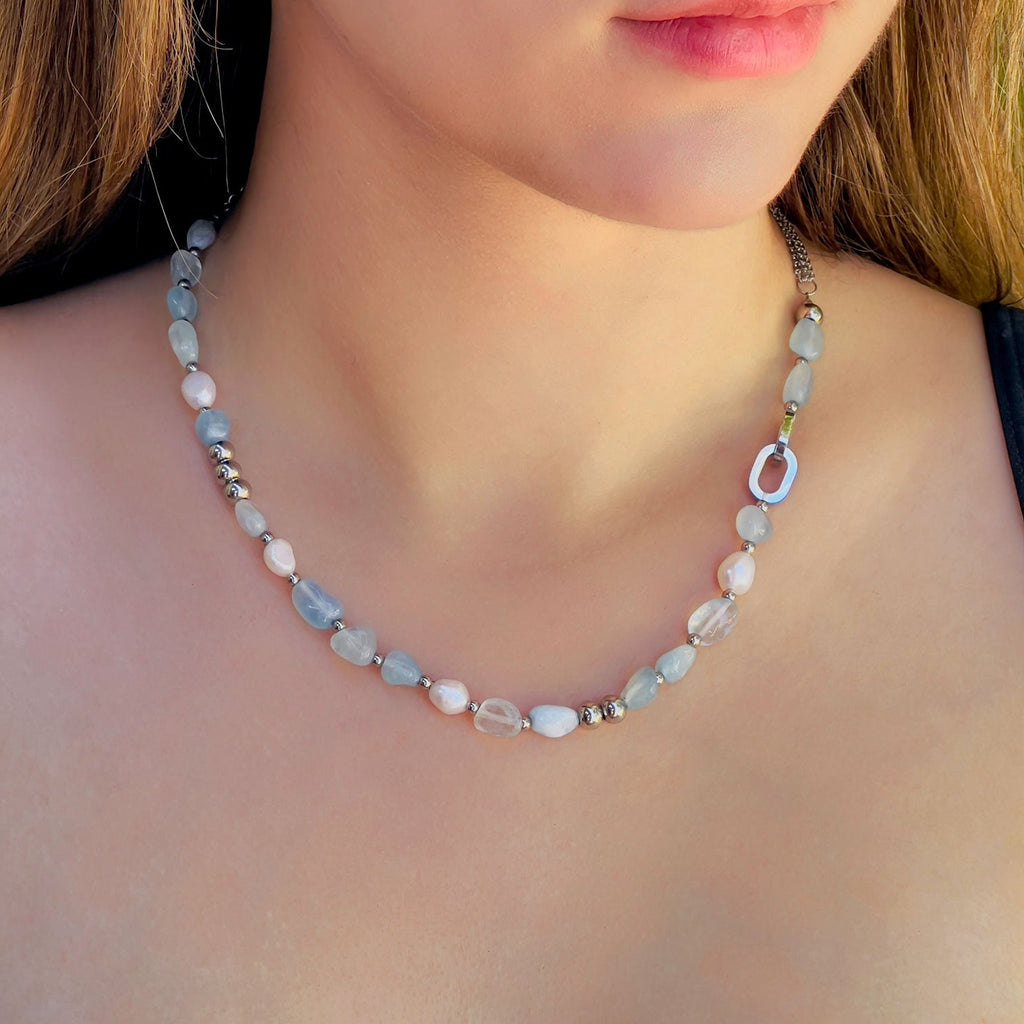 Girl wearing freshwater pearl and aquamarine blue crystal stones necklace, silver color stainless steel beaded chain.