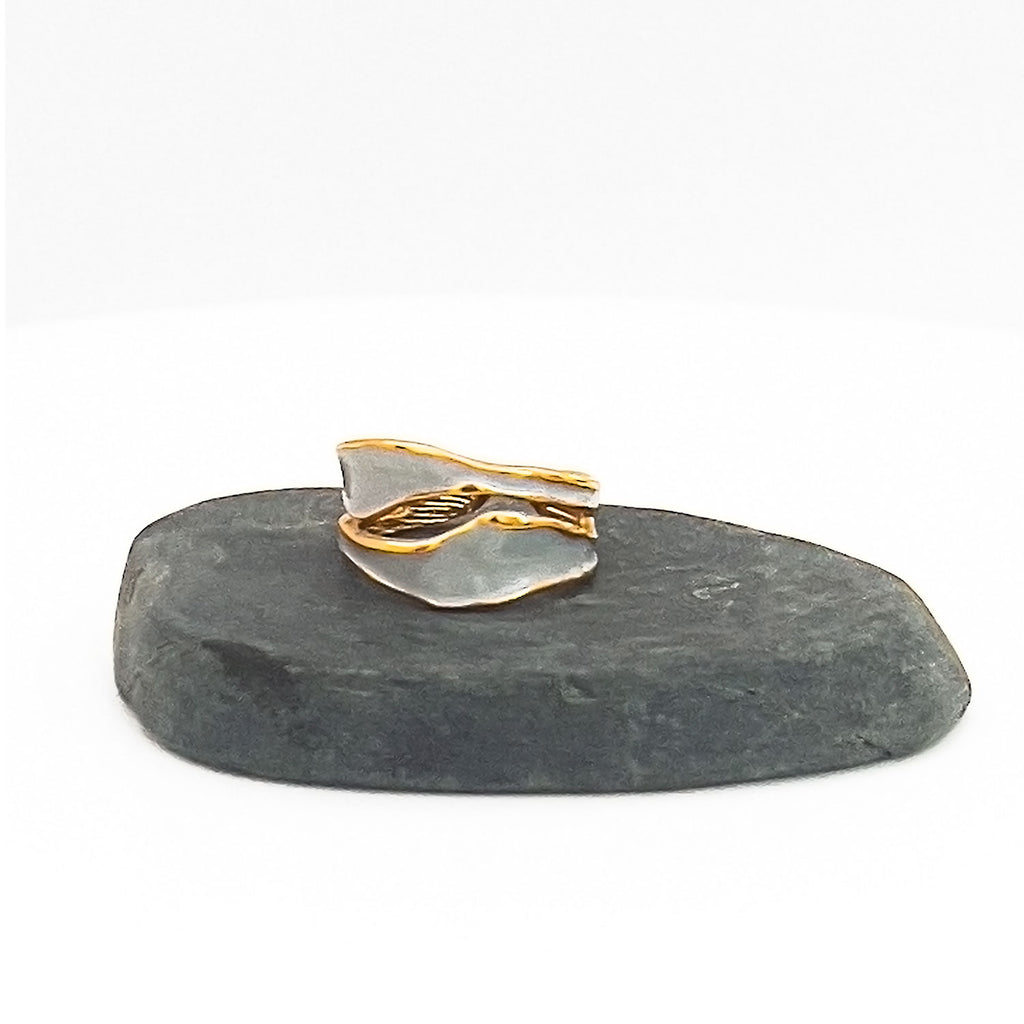 18k gold plated enamel ring. Adjustable ring with wavy structure, color light blue. Displayed on a stone.