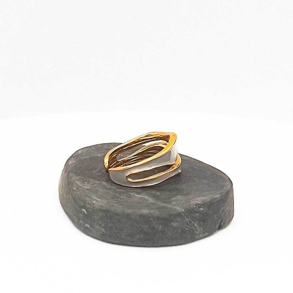 18k gold plated enamel ring. Adjustable ring with wavy structure, color light blue. Displayed on a stone.