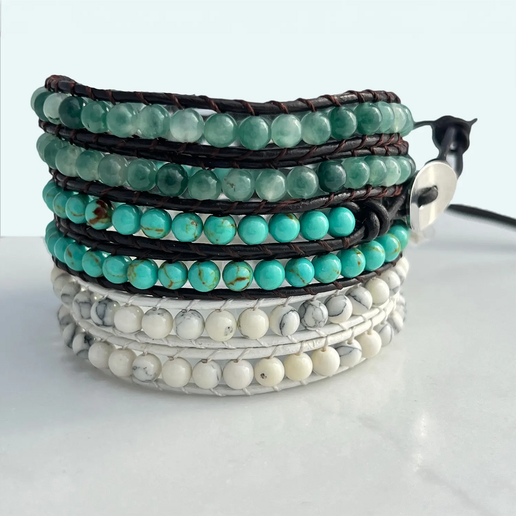 Three bracelets stacked together, top is jade multi-tone natural stone and brown faux leather beaded BOHO bracelet, middle is turquoise natural stone and brown faux leather beaded BOHO bracelet, bottom is the white marble natural stone beaded white faux leather bracelet.