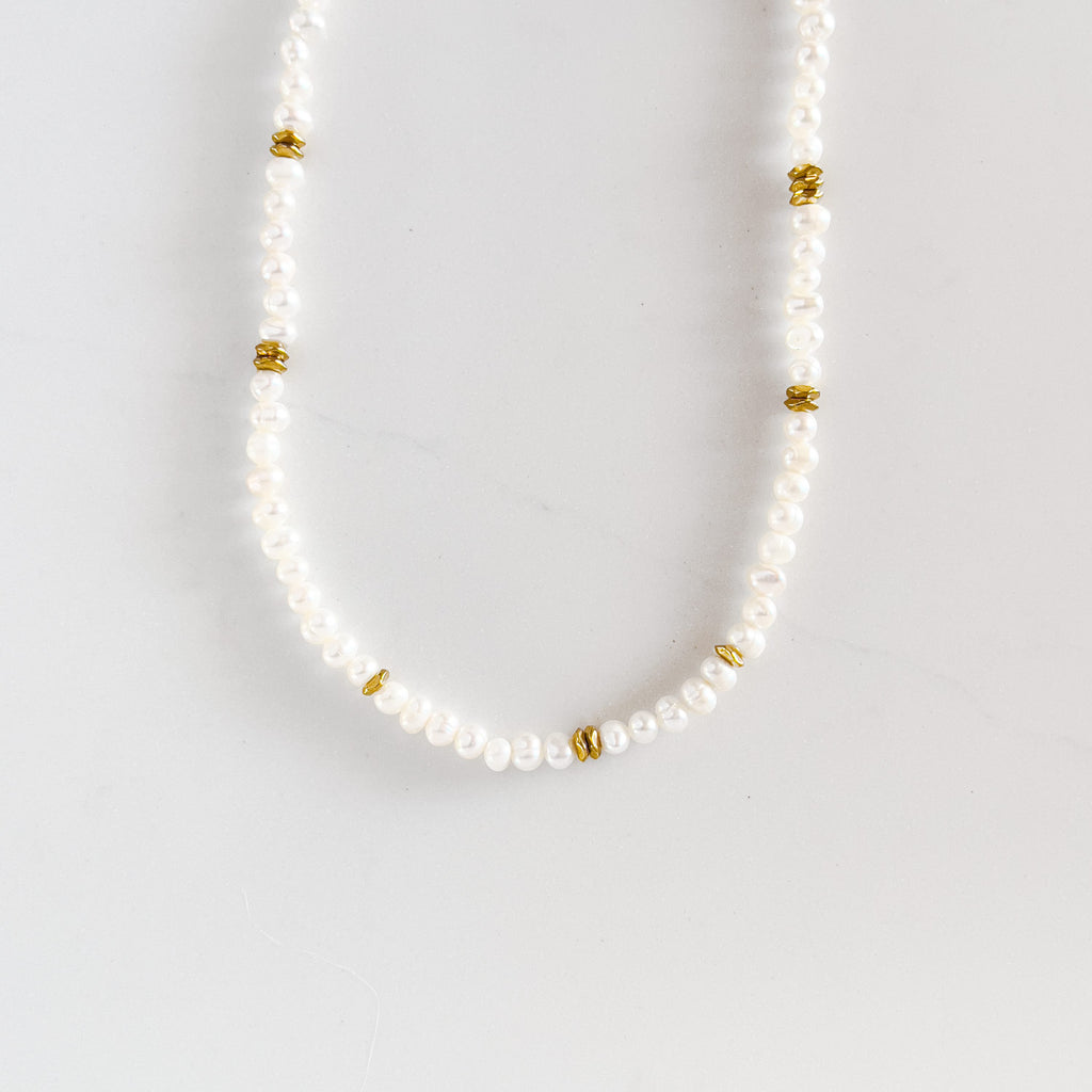 Freshwater pearl beaded necklace with 18k gold plated beads spaced out a few times along the necklace.