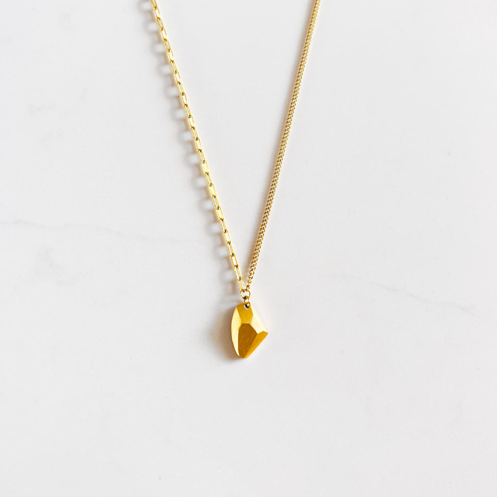 18k gold plated stainless steel cable and curb split chain with small geometric gold-plated rock style pendant. One half of chain is a wider open chain, the other half is a more compact chain.