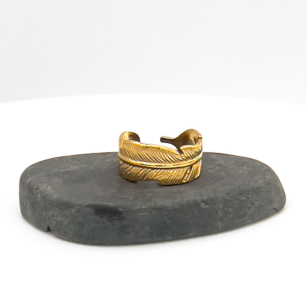 18k gold plated adjustable palm leaf ring. Ring engraved to represent a palm leaf. Ring displayed on rock.