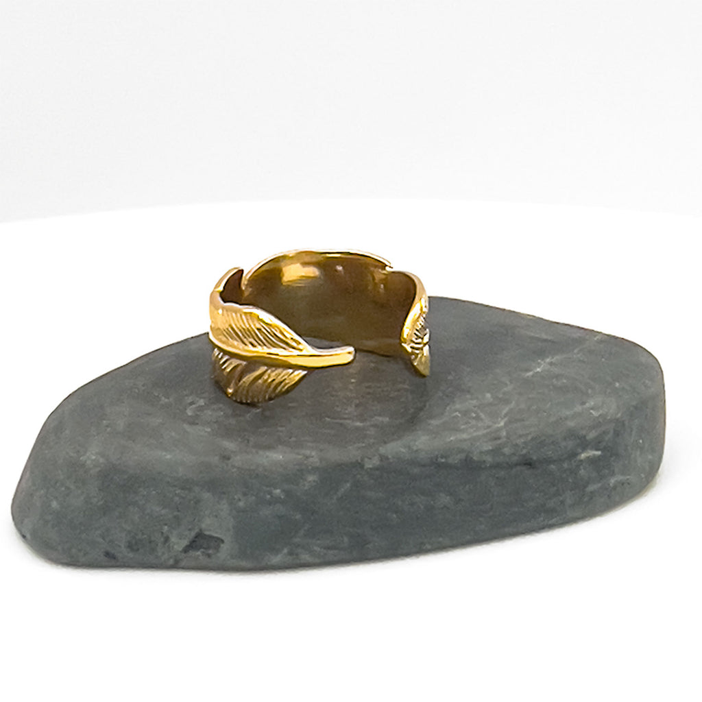 18k gold plated adjustable palm leaf ring. Ring engraved to represent a palm leaf. Ring displayed on rock.