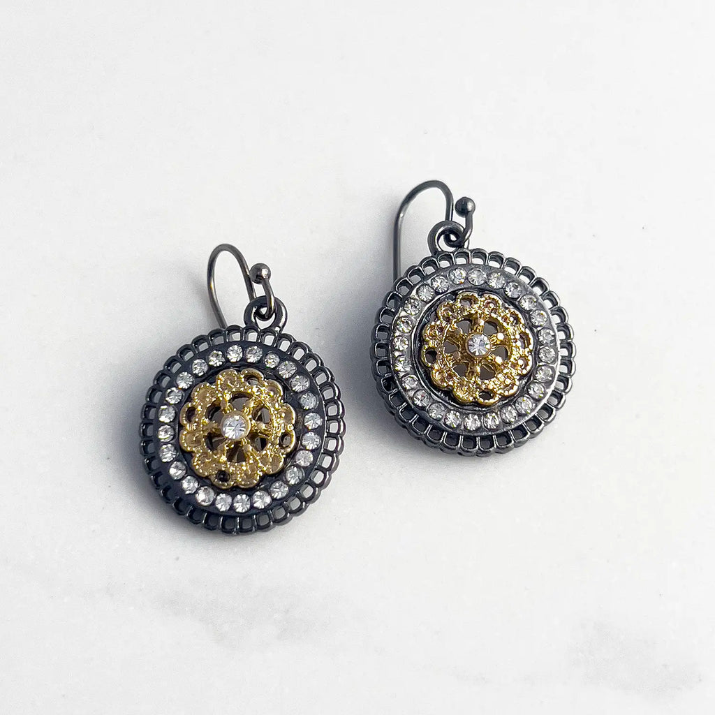 Iron-based Black metal and gold plated center pave drop earrings with fishhook backing. Earrings have small stones as accents in the earring round.
