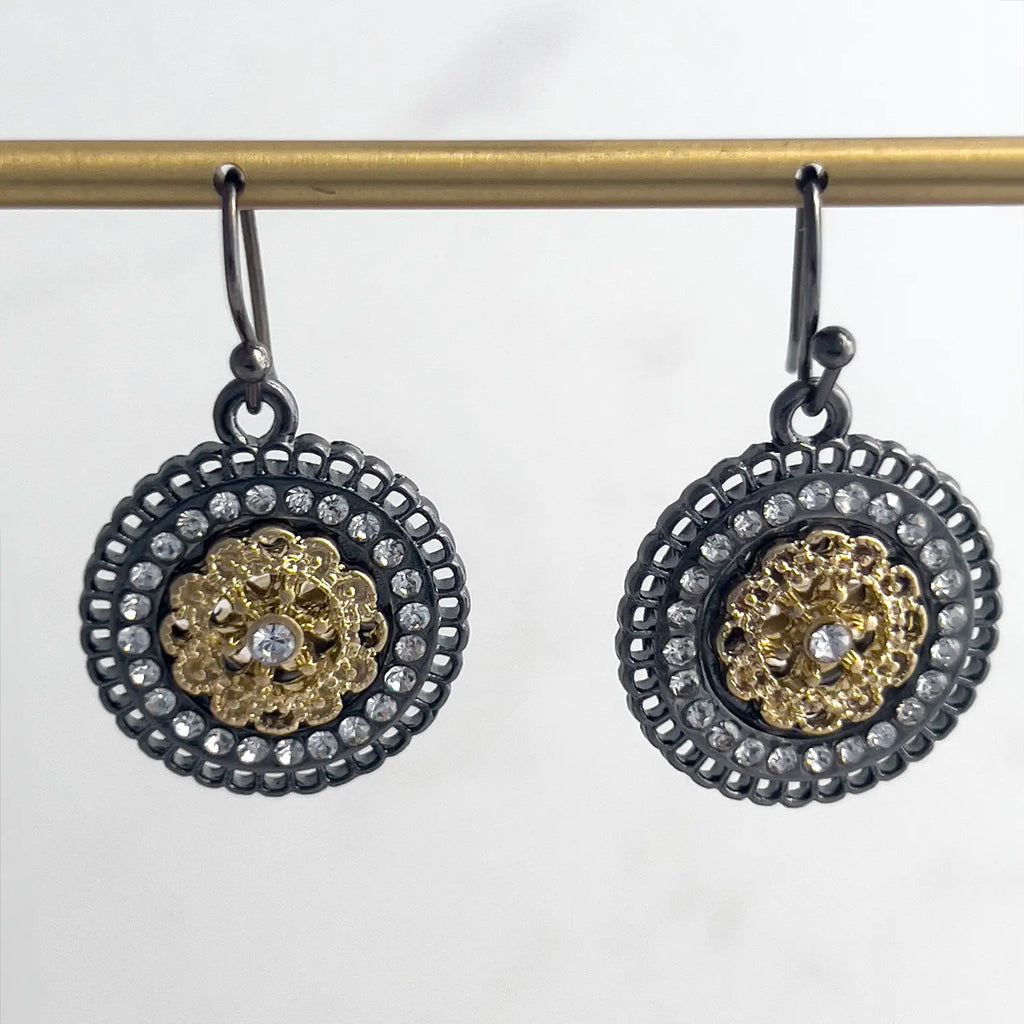 Iron-based Black metal and gold plated center pave drop earrings with fishhook backing. Earrings have small stones as accents in the earring round.