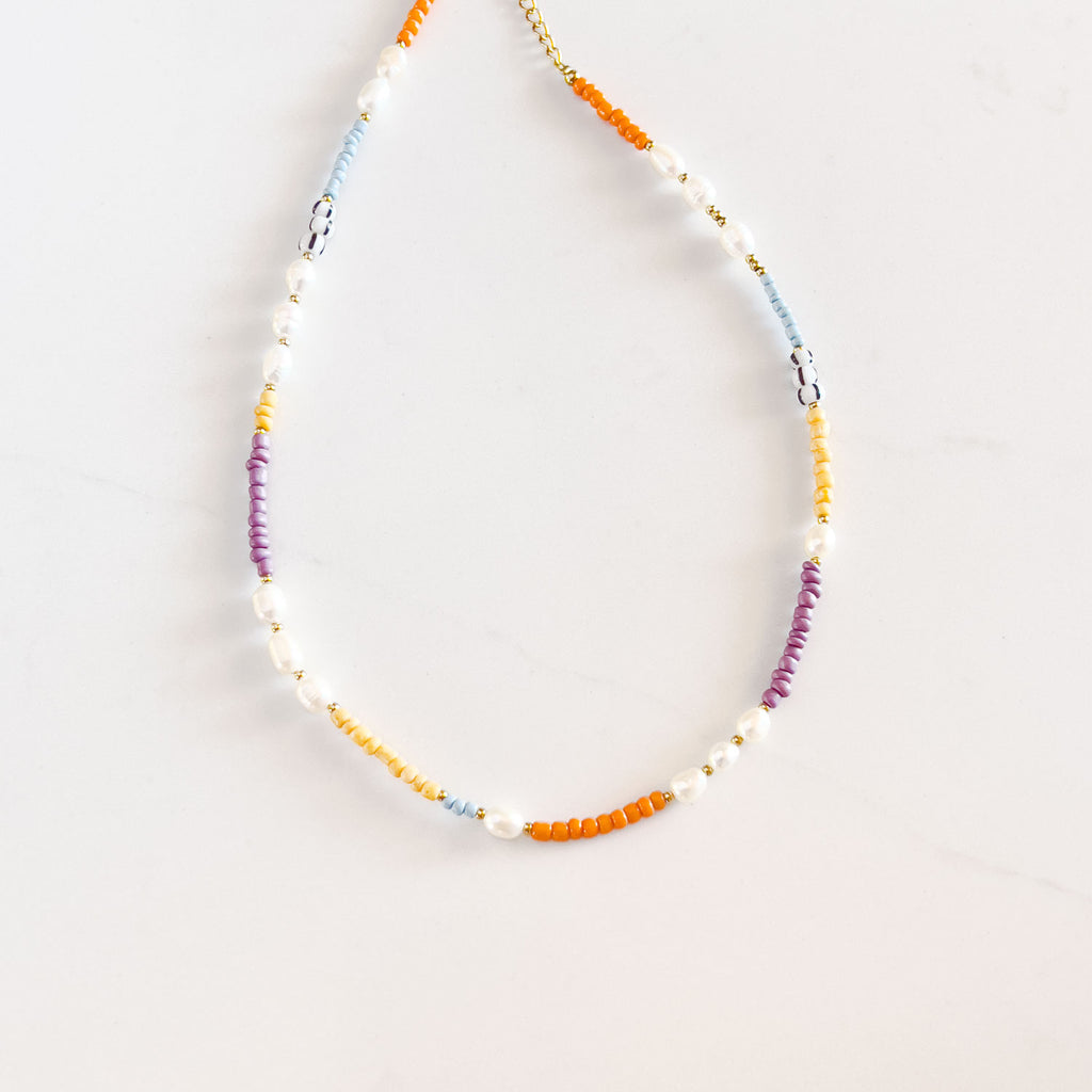 colorful beaded necklace choker necklace with freshwater pearl accents. The colors are blocked together and are purple, yellow, orange and blue.
