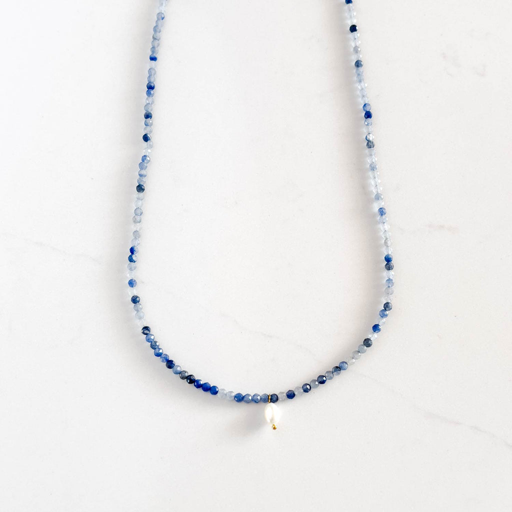 Beaded blue aventurine necklace with different shades of blue and a small freshwater pearl pendant.