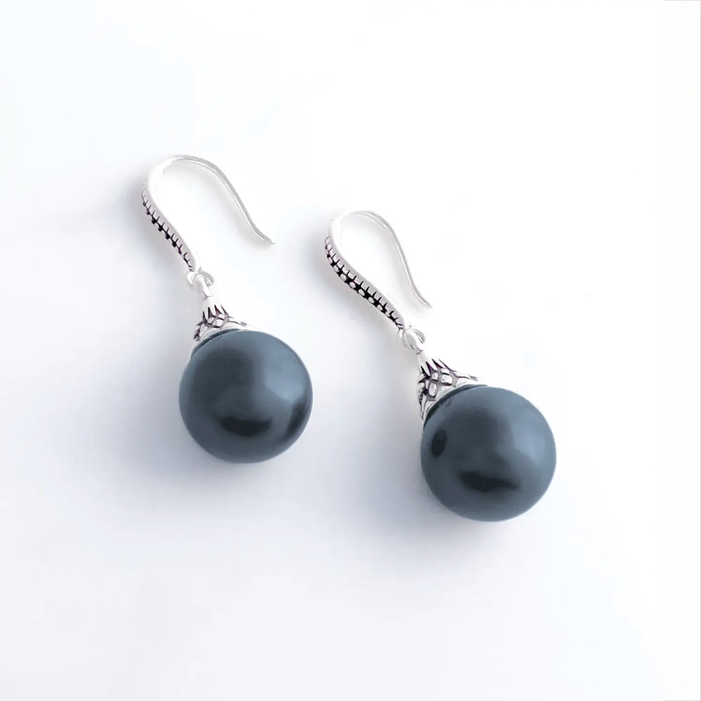 black freshwater pearl and sterling silver drop earrings with a fishhook backing. Sterling silver has a pattern engraved.