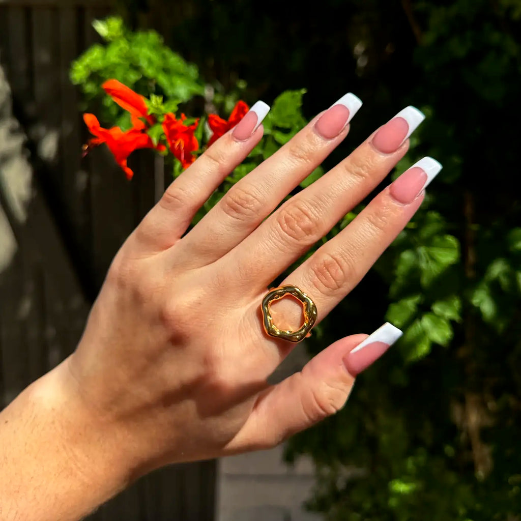 hand displaying 18k gold plated ring with slightly mishapen circle. (abstract "O" on top)