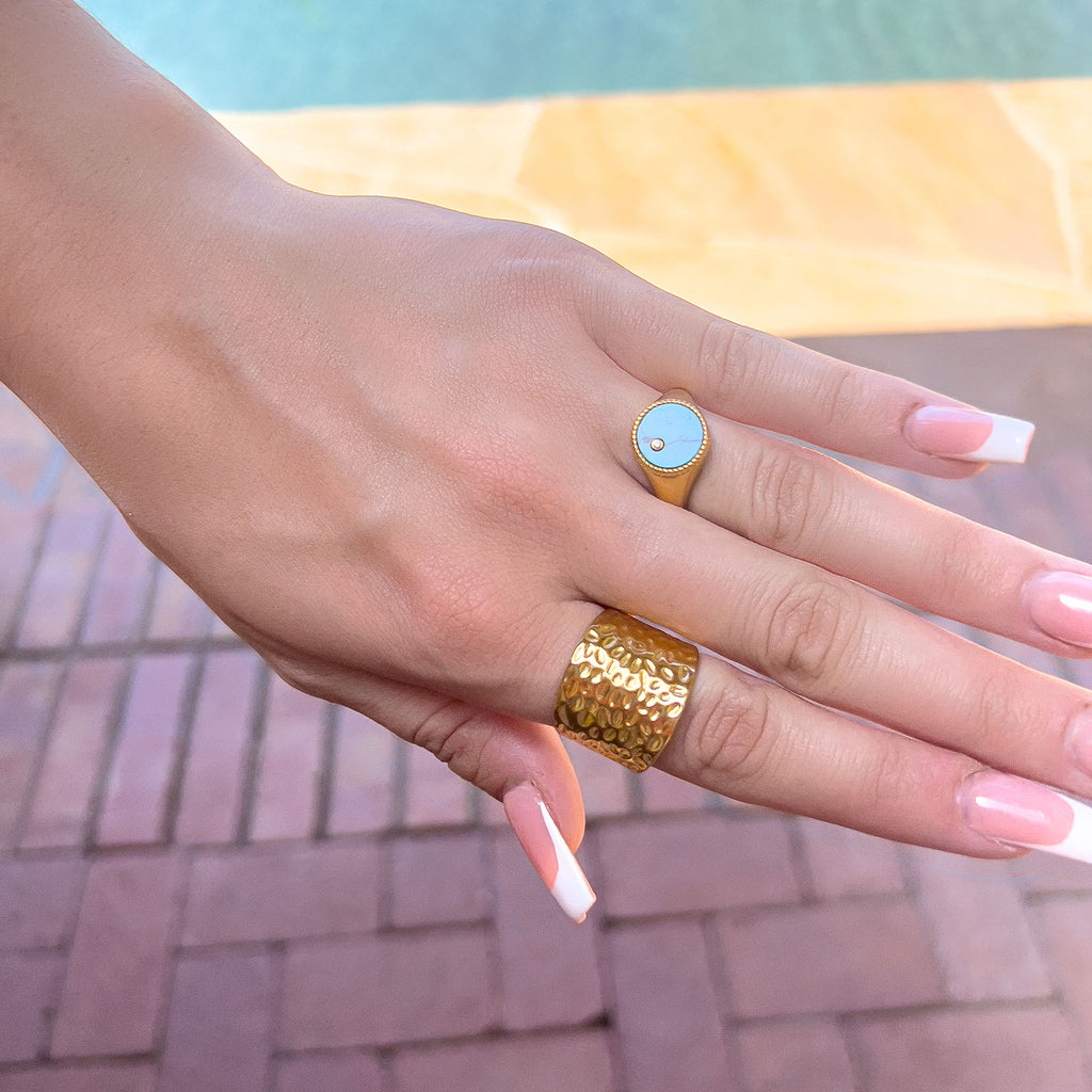 Girls hand displaying 18k gold plated "hammered" adjustable ring, wide and plate with indented pattern.