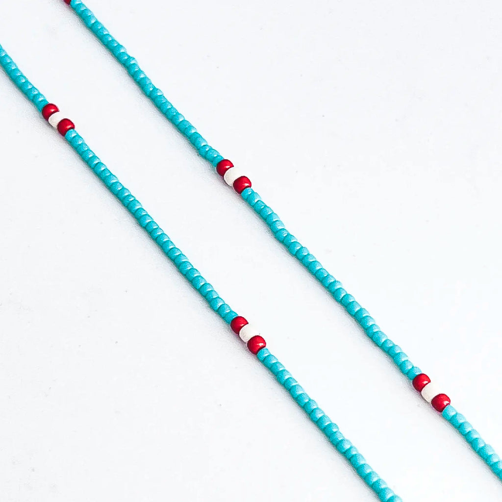 Thin turquoise beaded necklace, red bead accents along chain.