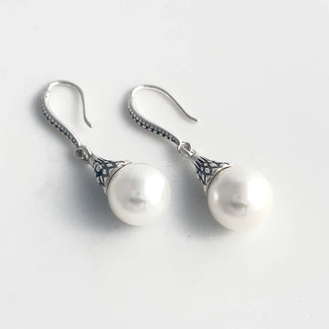 freshwater pearl and sterling silver drop earrings with a fishhook backing. Sterling silver has a pattern engraved.