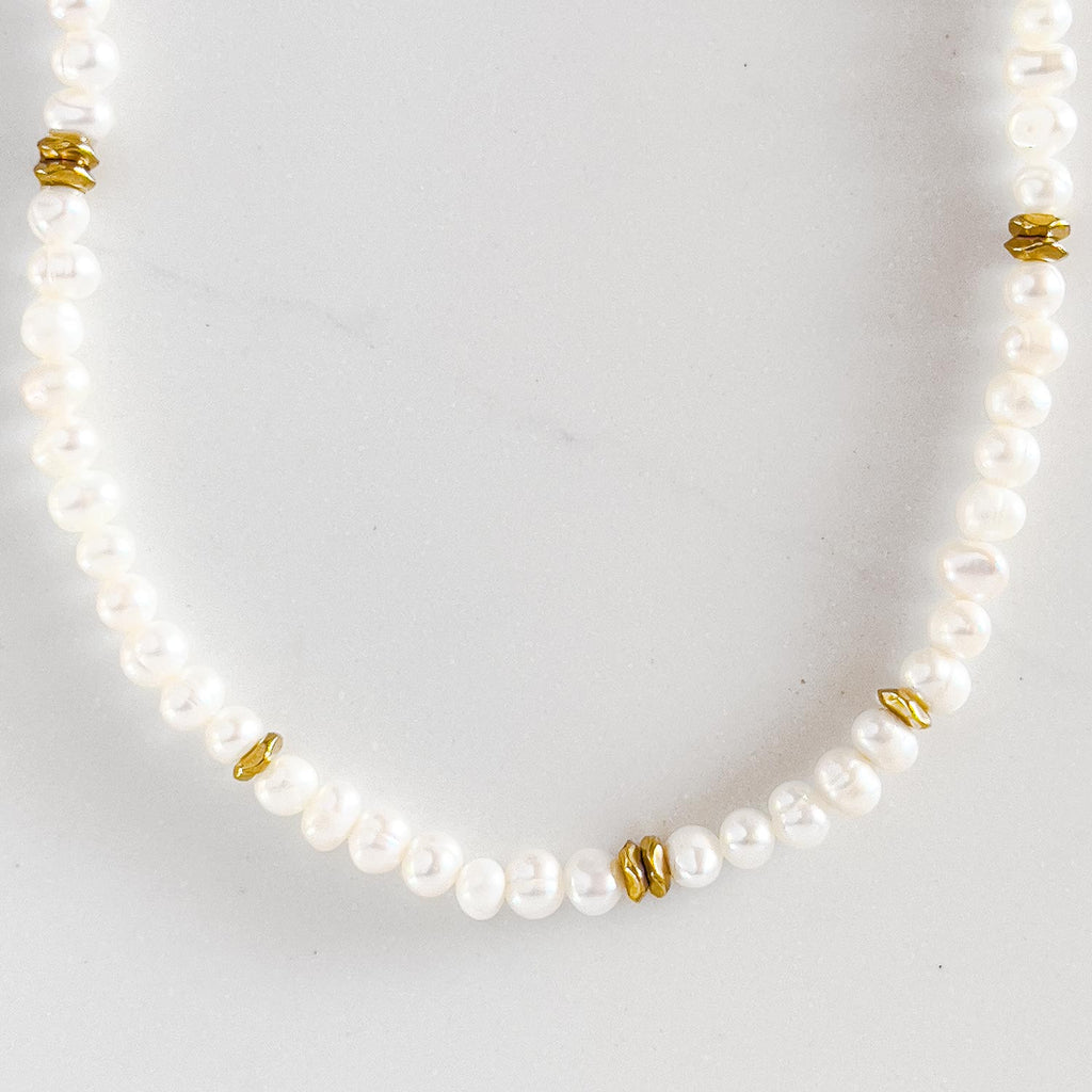 Freshwater pearl beaded necklace with 18k gold plated beads spaced out a few times along the necklace.